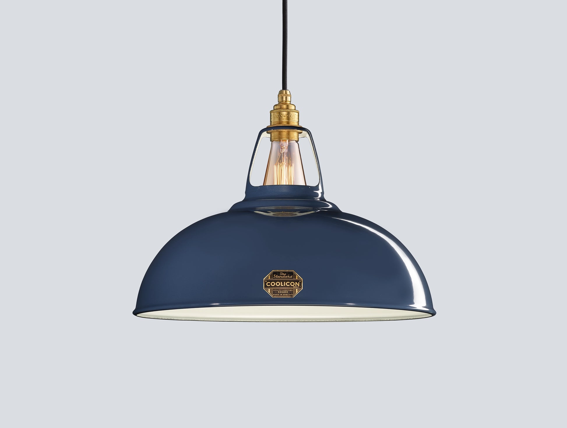 Large Selvedge blue Coolicon lampshade with a Signature Brass pendant set over a light blue background