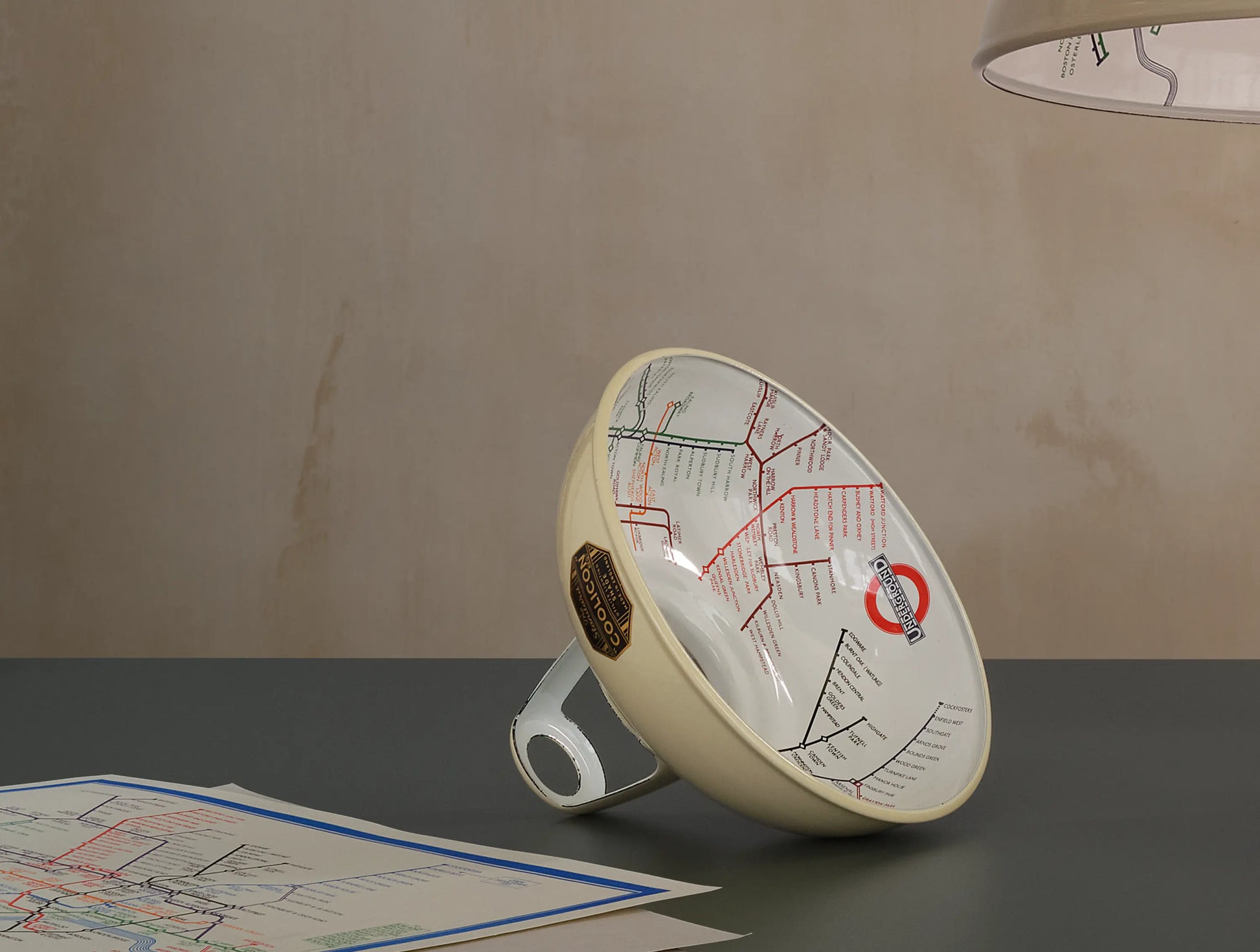 An Original Paper Cream shade on a table. There are a couple of printed 1933 maps on the left